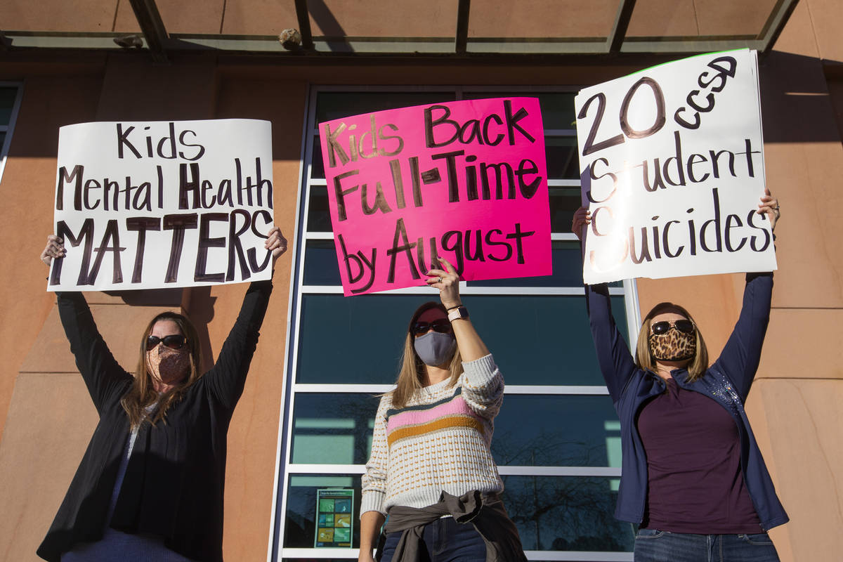 Melinda Anderson, left, Julie Shipp and Brooke Watson protest for their children to go back to ...