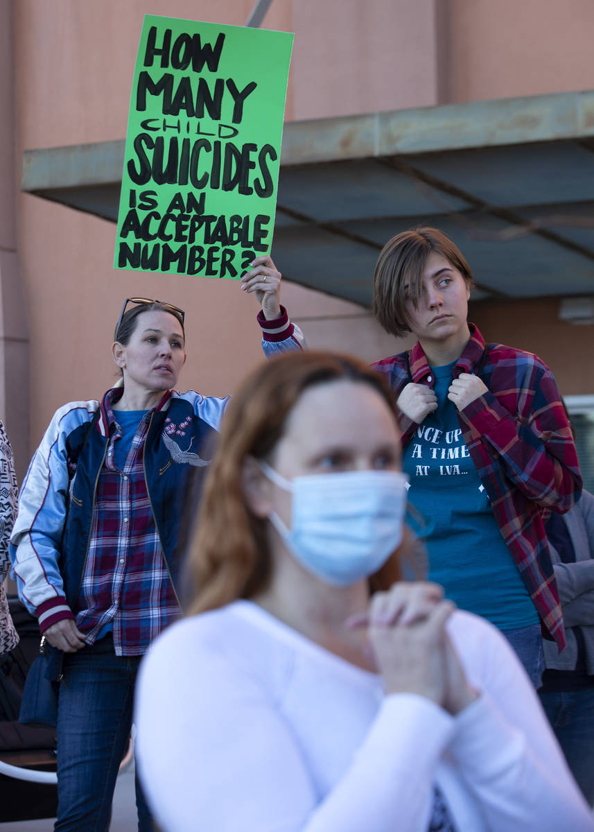 Ashley Coder, a CCSD mom, left, and Emma Czarnecki, a CCSD sophomore, right, attend a protest o ...
