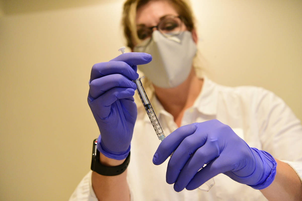 This September 2020 shows a pharmacist preparing to give an experimental COVID-19 vaccine. (Joh ...