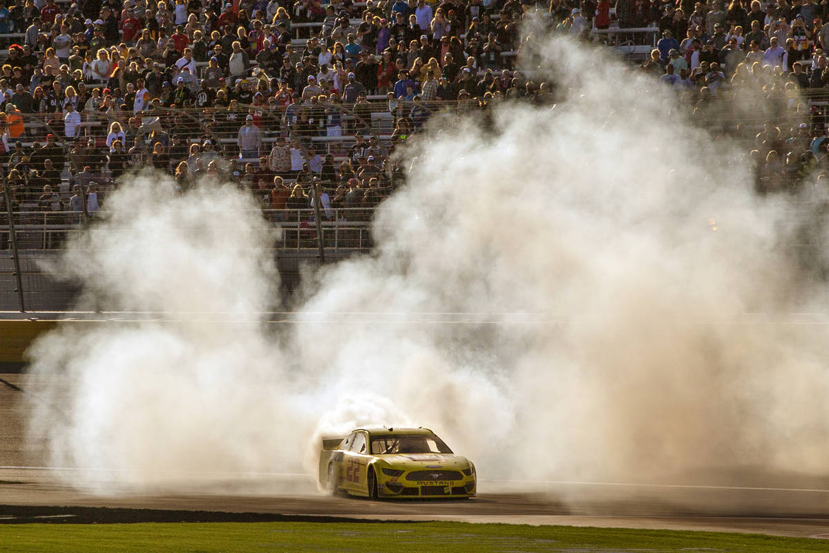 Joey Logano (22) celebrates with a burn out at the finish line following his win in the Pennzoi ...