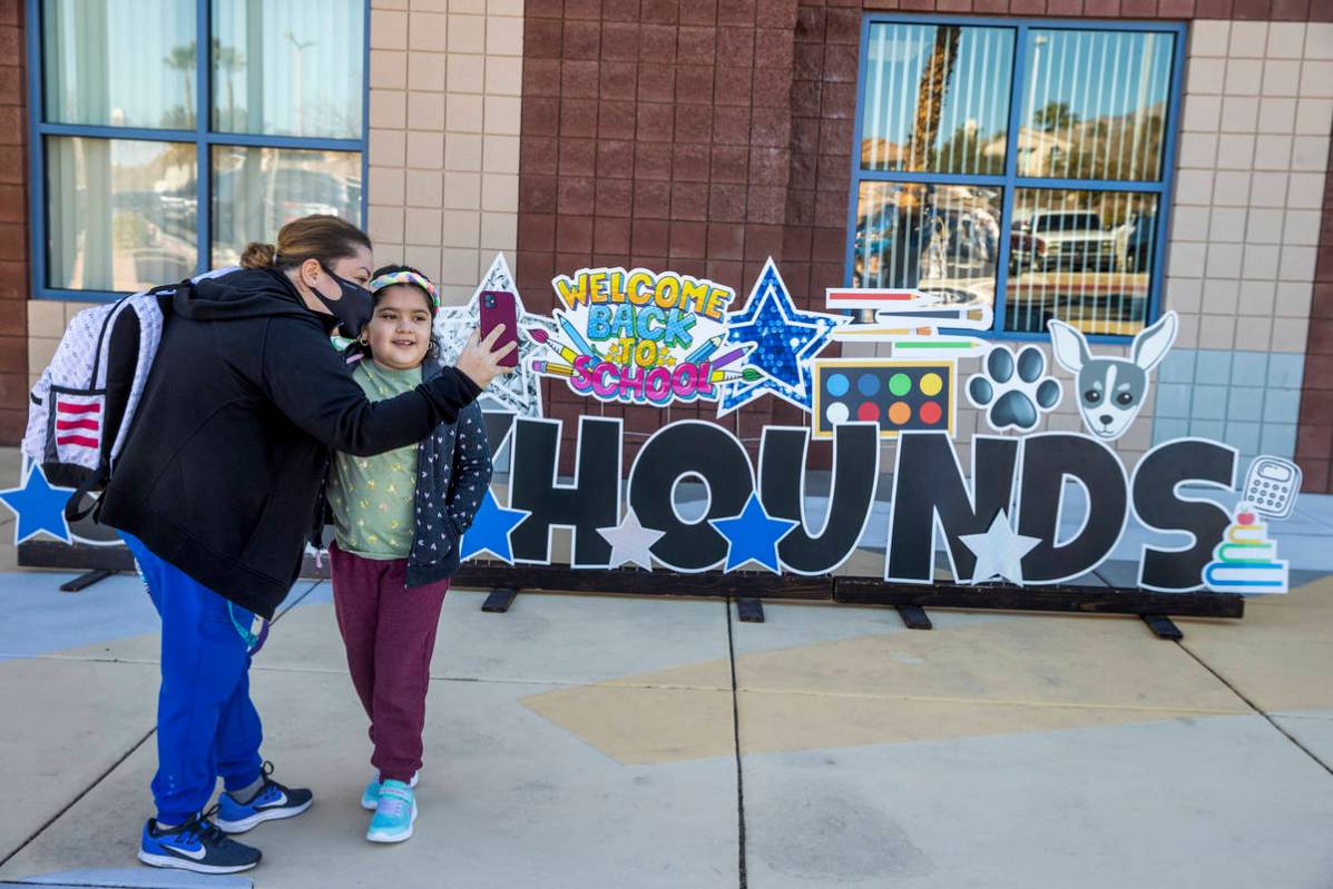 Lupe Tapia and her daughter Ariel, 8, take a photo outside of Goolsby Elementary School as she ...