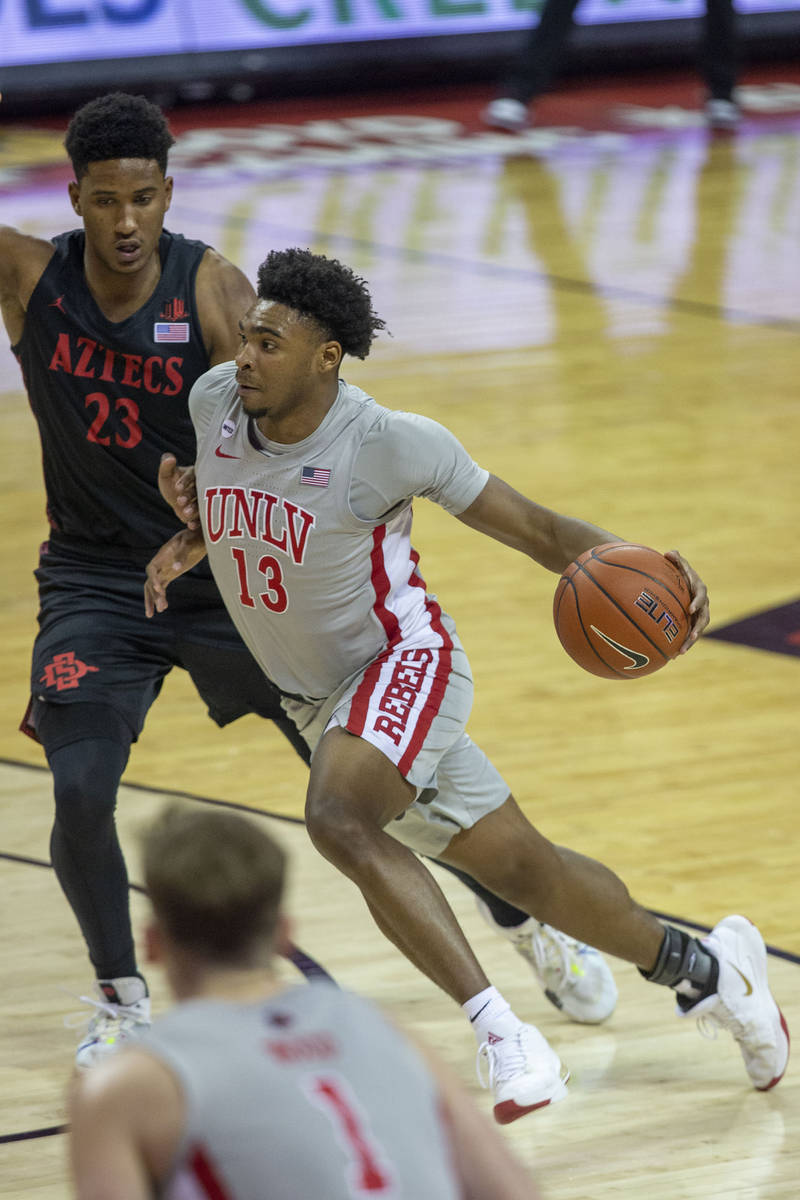 UNLV Rebels guard Bryce Hamilton (13) dribbles past San Diego State Aztecs forward Joshua Tomai ...