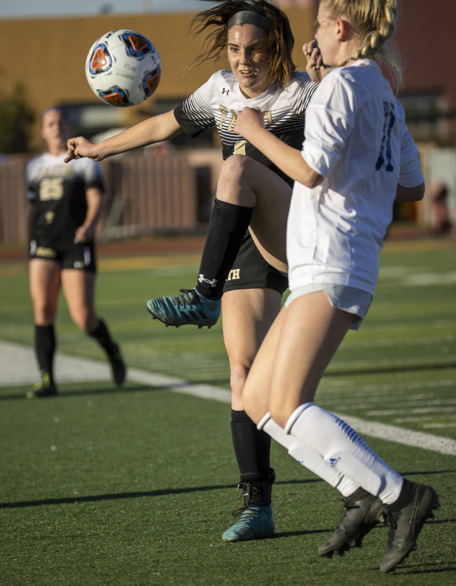 Faith Lutheran's Mackenzie Folk (8) defends the ball away from Bishop Gorman's Michelle Madrid ...