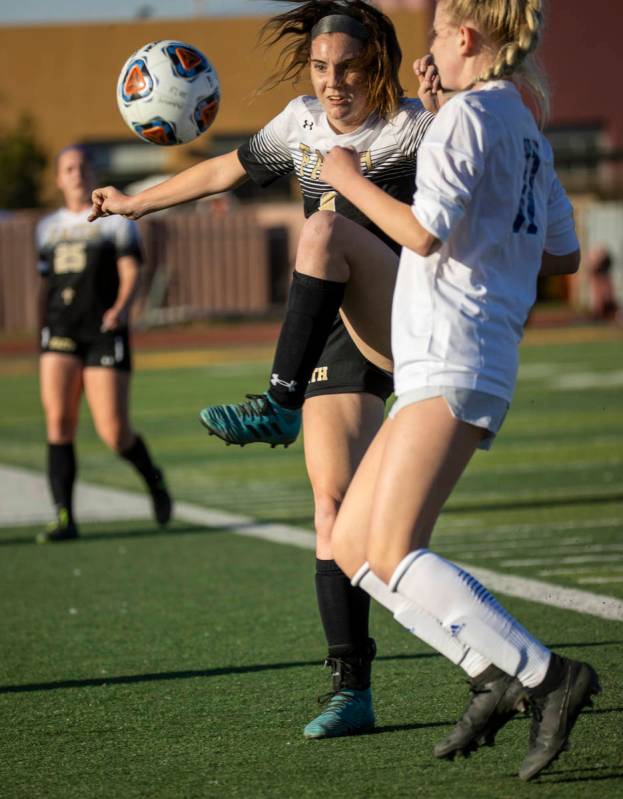 Faith Lutheran's Mackenzie Folk (8) defends the ball away from Bishop Gorman's Michelle Madrid ...
