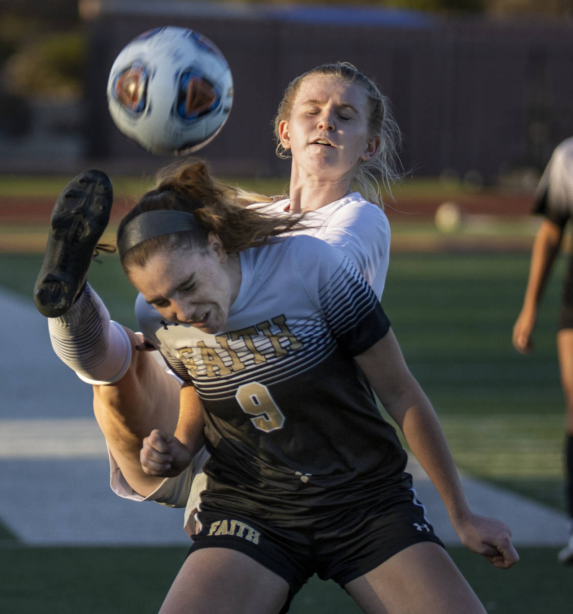Faith Lutheran's Claire Dalbec (9) has a ball kicked past her head by Bishop Gorman's Michelle ...