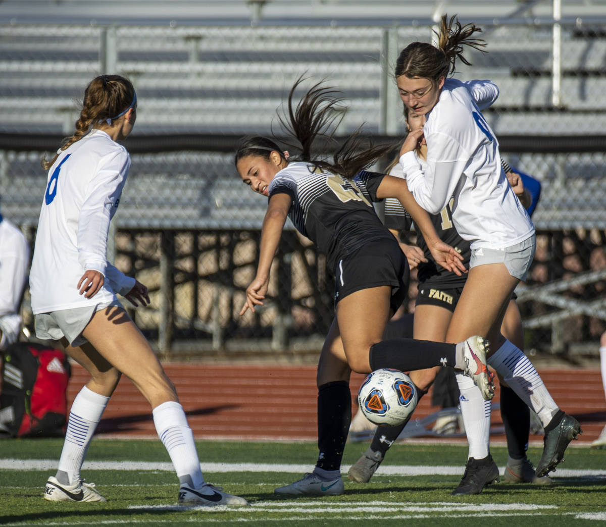 Faith Lutheran's Aurrianna Parker (21, center) fights for the ball with Bishop Gorman's Rachel ...