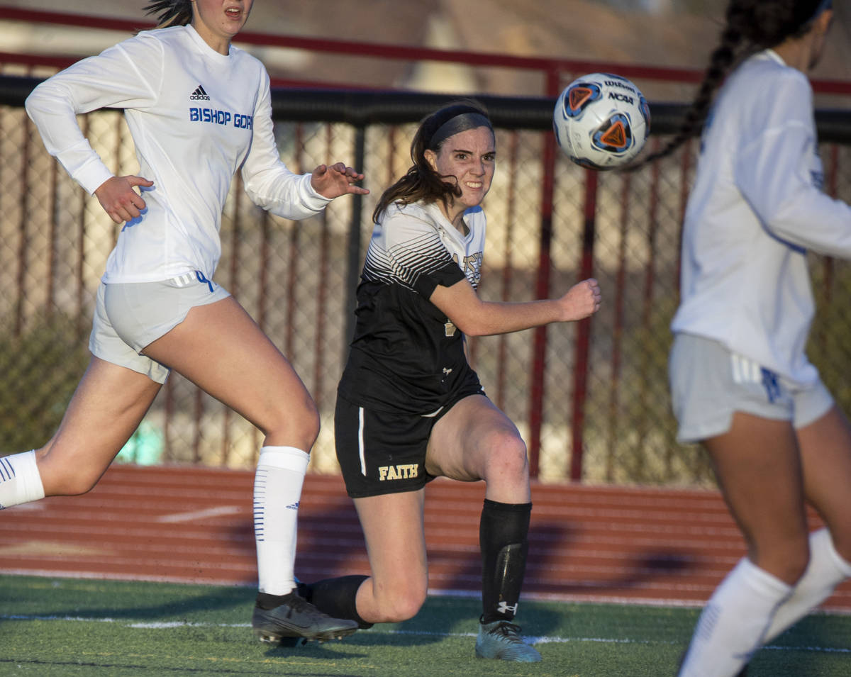 Faith Lutheran's Claire Dalbec (9) drives the ball towards the goal with Bishop Gorman defender ...
