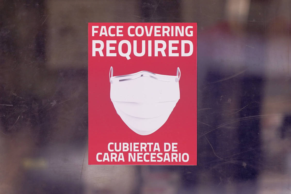 A mask required sign is displayed on the entrance to a business Tuesday, March 2, 2021, in Dall ...