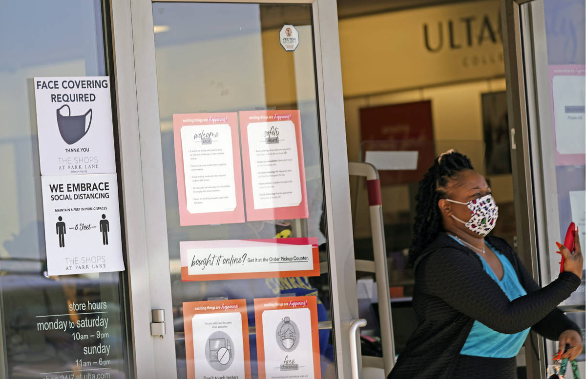 A customer exits a store with a mask required sign displayed, Tuesday, March 2, 2021, in Dallas ...