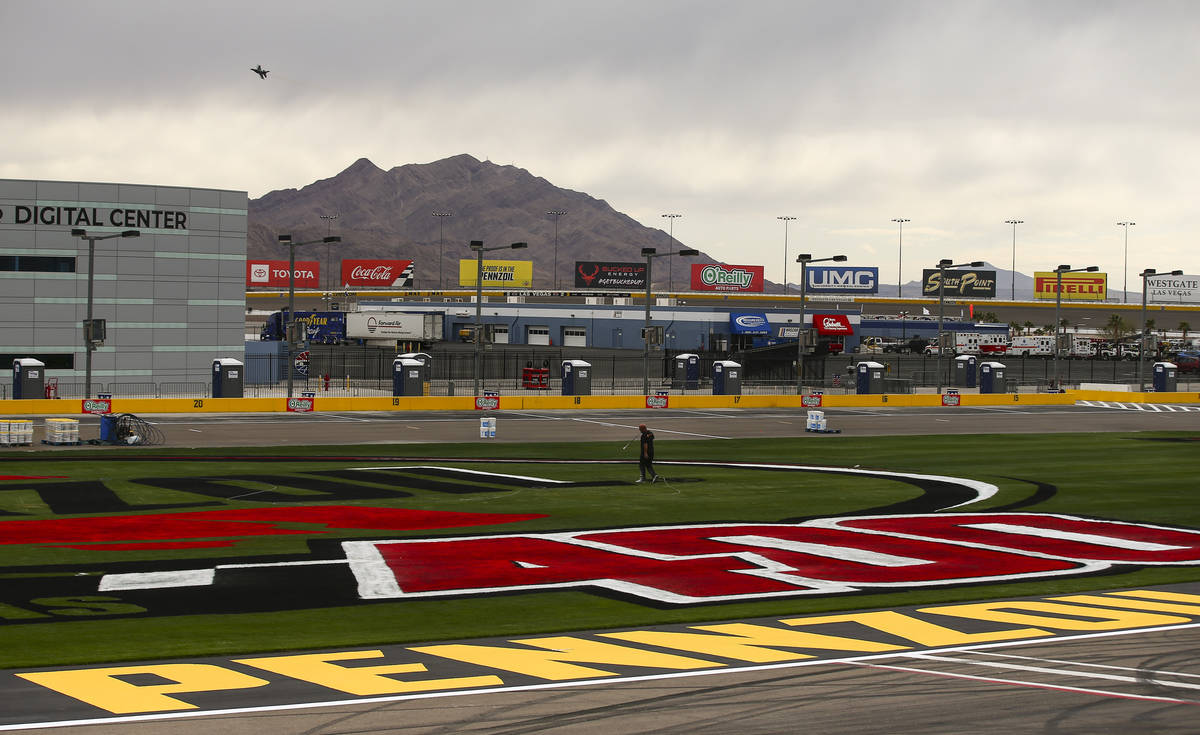 Dale Pantelakis, of Ananta Surfaces, paints logos on the infield grass ahead of the Pennzoil 40 ...