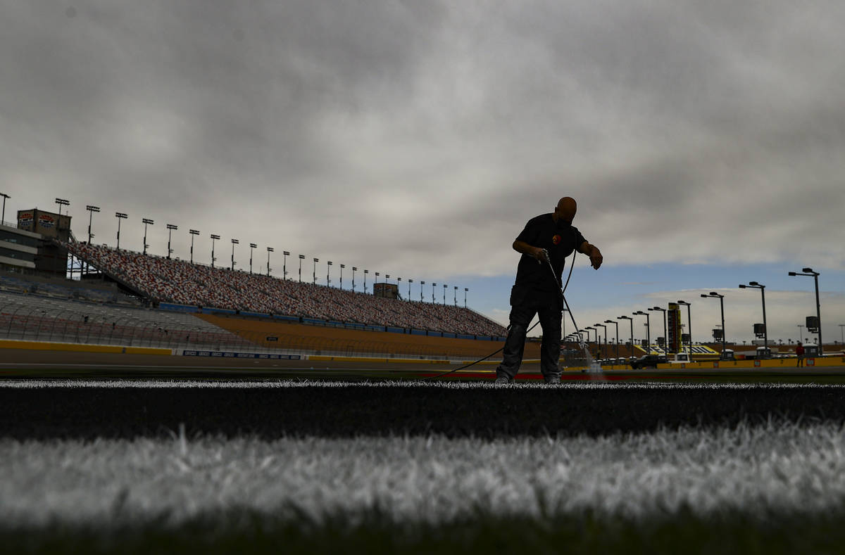 Dale Pantelakis, of Ananta Surfaces, paints logos on the infield grass ahead of the Pennzoil 40 ...