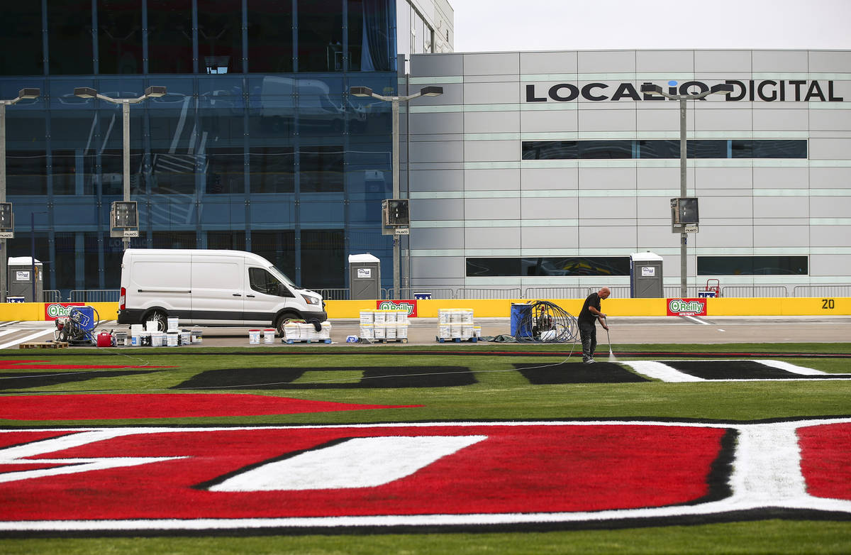 Dale Pantelakis, of Ananta Surfaces, paints logos on the infield grass ahead of the Pennzoil 40 ...