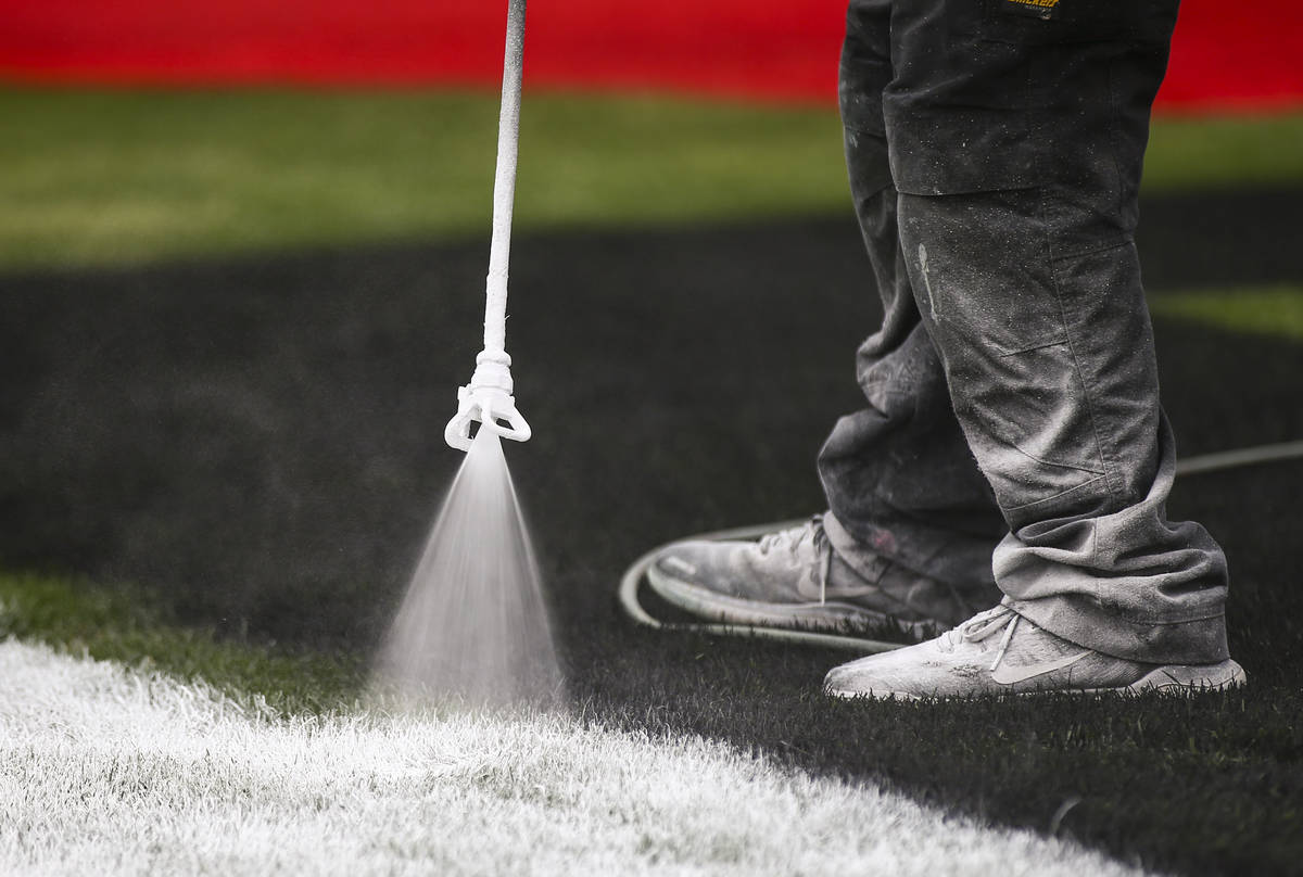 Dale Pantelakis, of Ananta Surfaces, paints logos on the infield grass ahead of the Pennzoil 40 ...