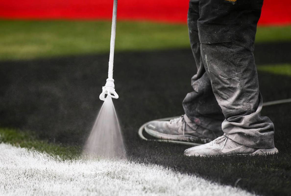 Dale Pantelakis, of Ananta Surfaces, paints logos on the infield grass ahead of the Pennzoil 40 ...