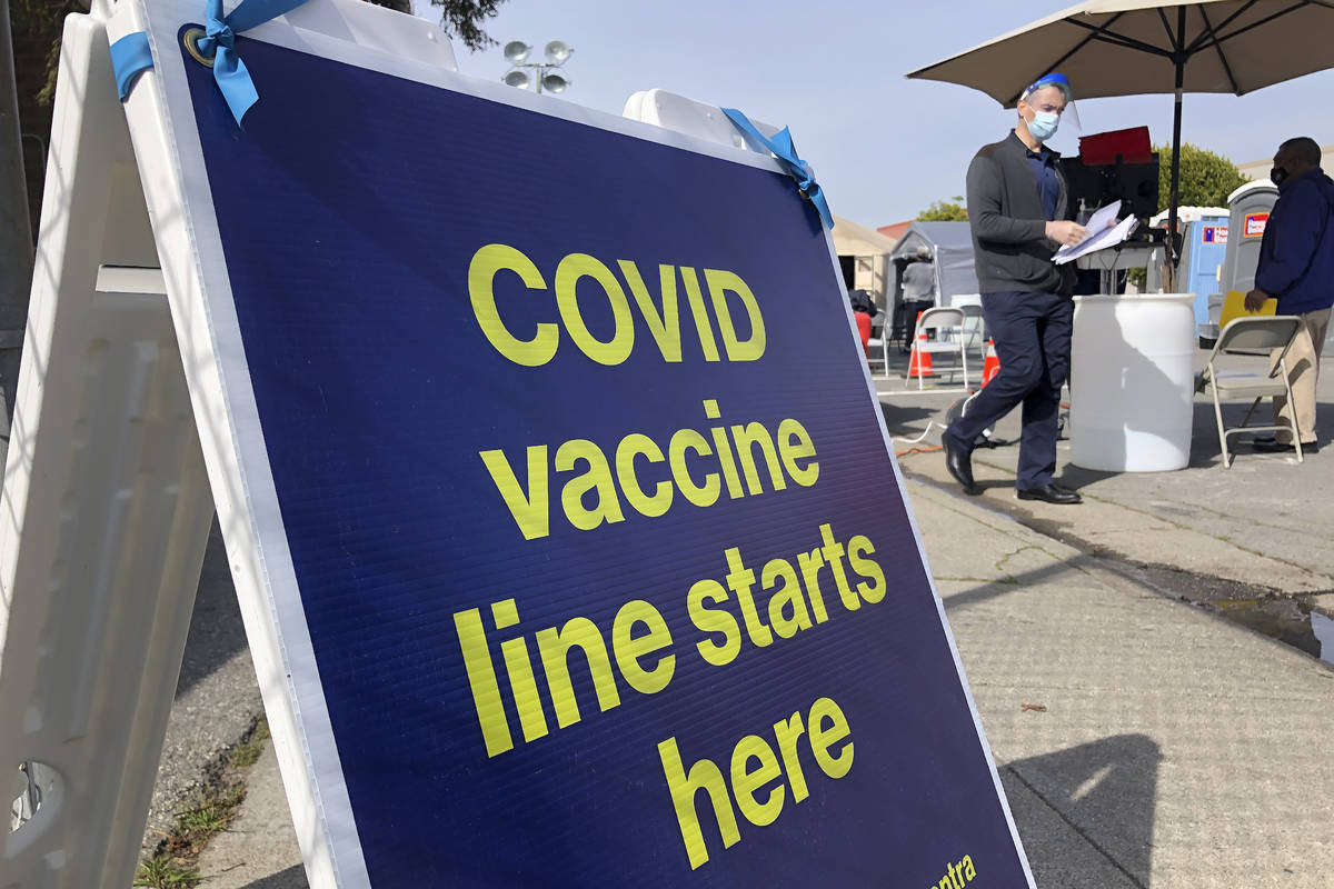 A sign is shown at a COVID-19 vaccine site in the Bayview neighborhood of San Francisco in Febr ...