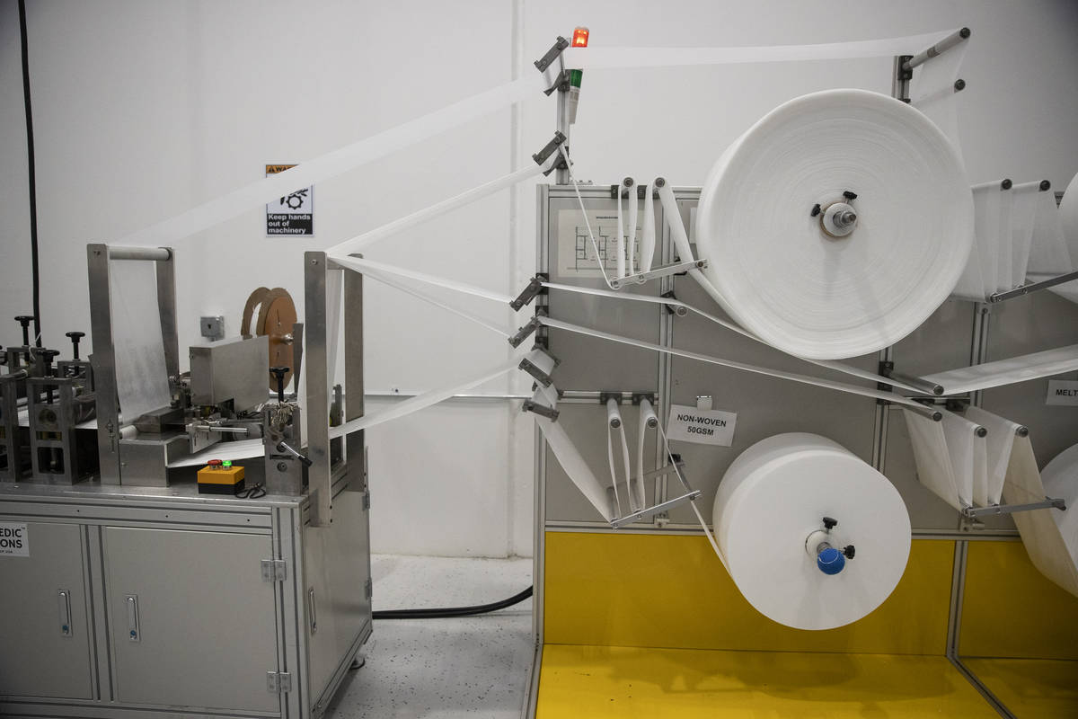 An N95 mask production machine runs fabric through a machine at the PandMedic Solutions headqua ...