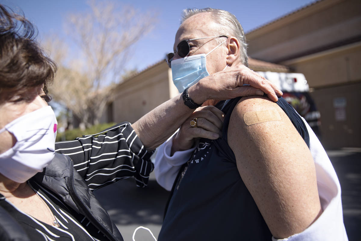 Sandra Hahnenkratt, left, shows her husband Ronald Griebell's band-aid from his vaccination sho ...