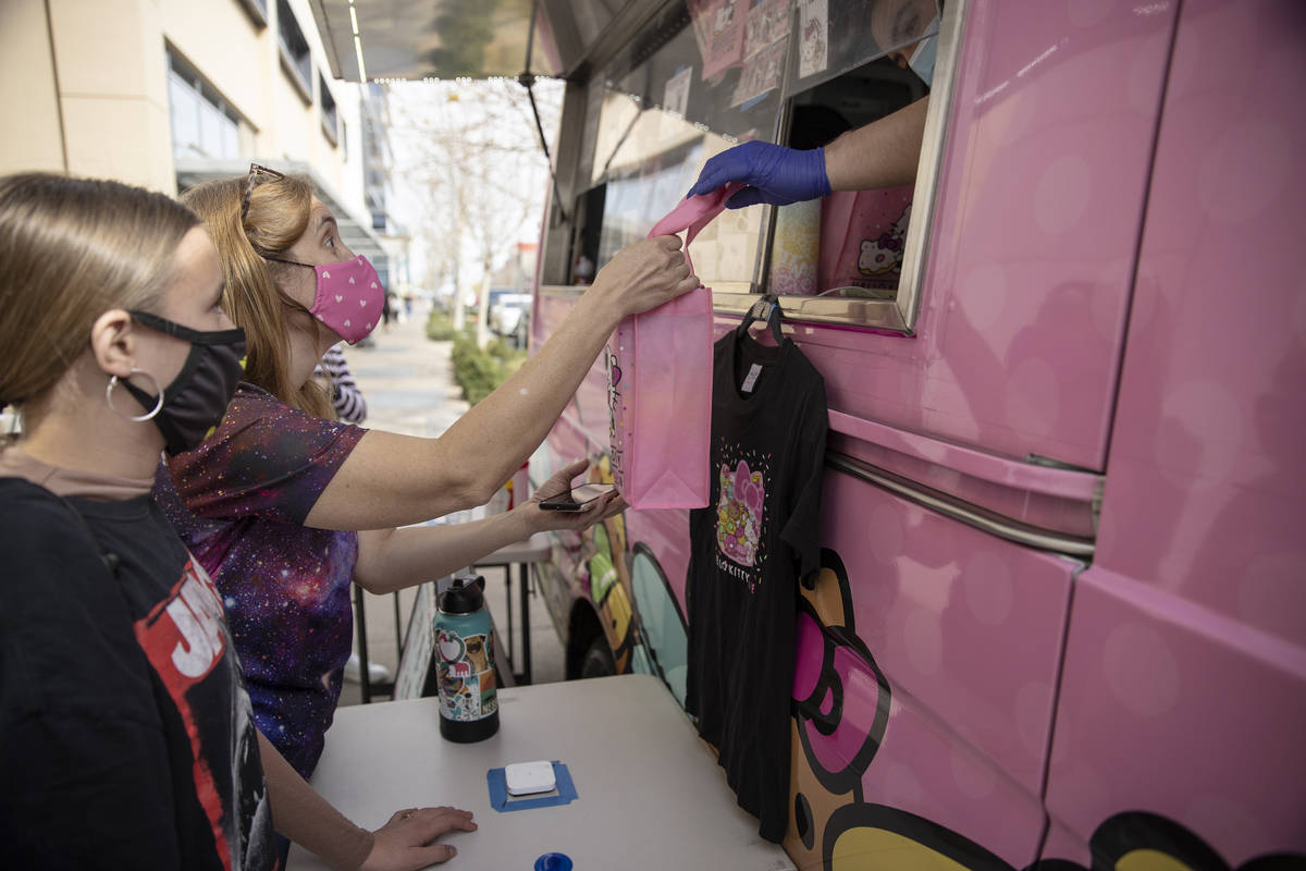 Kara Ness, center, and her daughter Ella Ness-Pavlinsky, 13, grab their purchase from the Hello ...