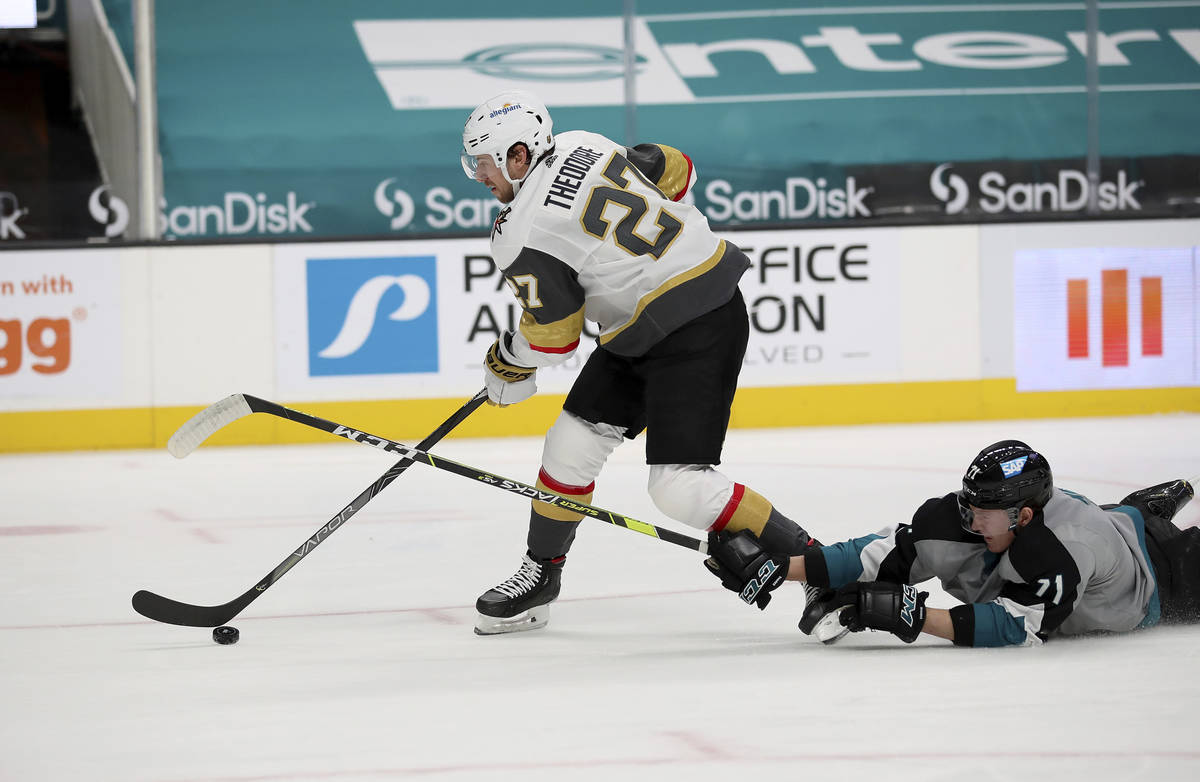 Vegas Golden Knights defenseman Shea Theodore (27) moves the puck down the ice next to a fallen ...