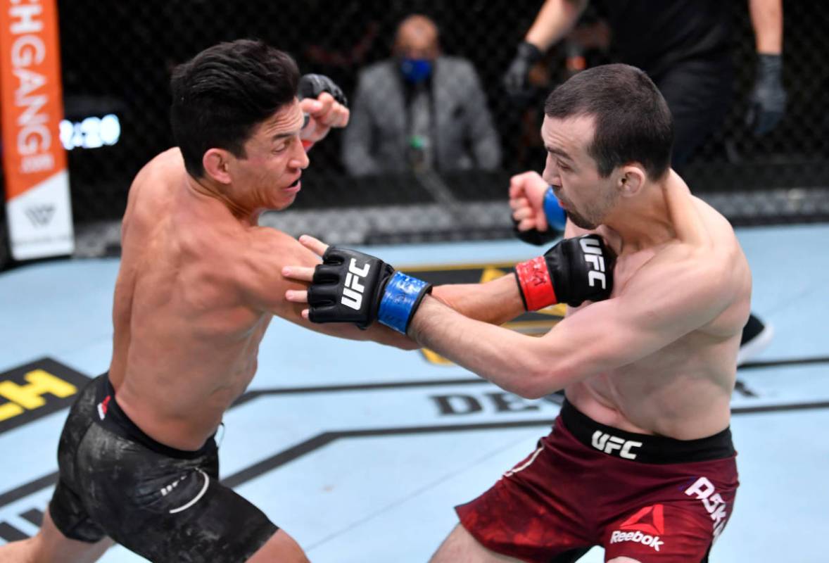 LAS VEGAS, NEVADA - MARCH 06: (L-R) Joseph Benavidez punches Askar Askaarov of Russia in their ...