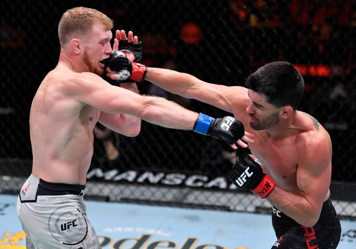 LAS VEGAS, NEVADA - MARCH 06: (R-L) Dominick Cruz punches Casey Kenney in their bantamweight fi ...