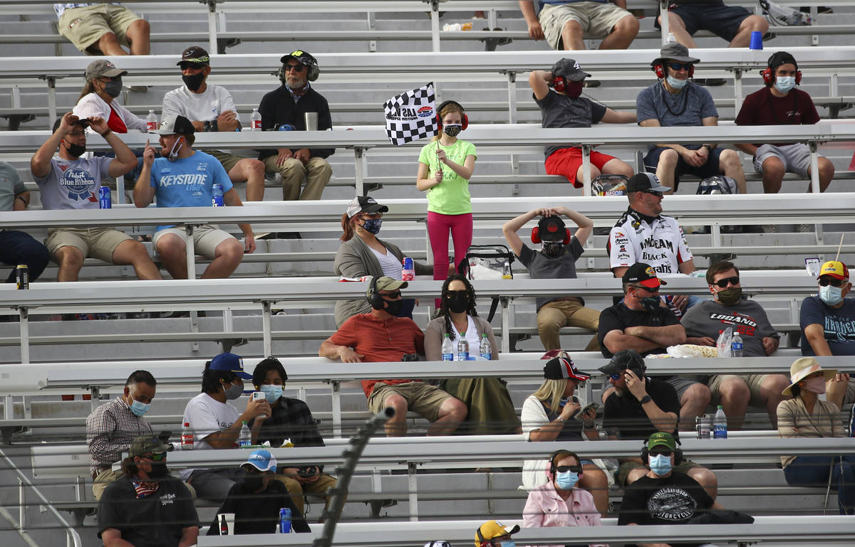 A young fan waves a checkered flag near the end of the NASCAR Cup Series Pennzoil 400 auto race ...