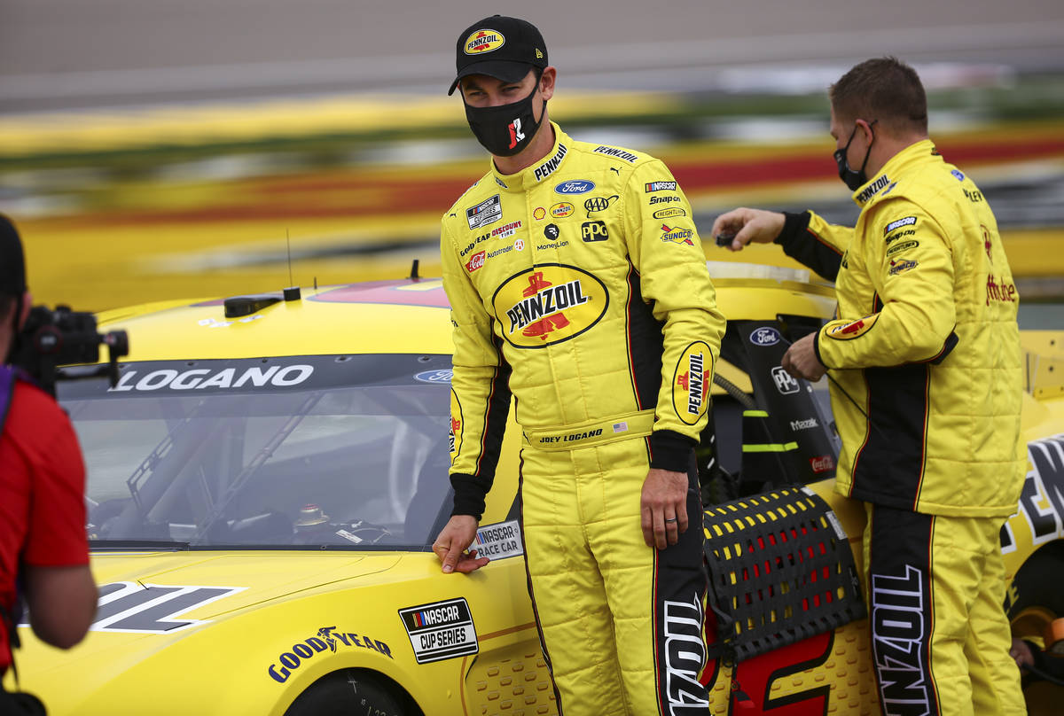 Joey Logano stands by his car before the start of the NASCAR Cup Series Pennzoil 400 auto race ...
