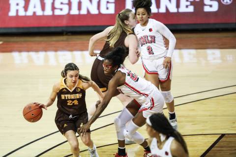 Wyoming guard Tommi Olson (24) dribbles past UNLV center Desi-Rae Young (23) in the second half ...