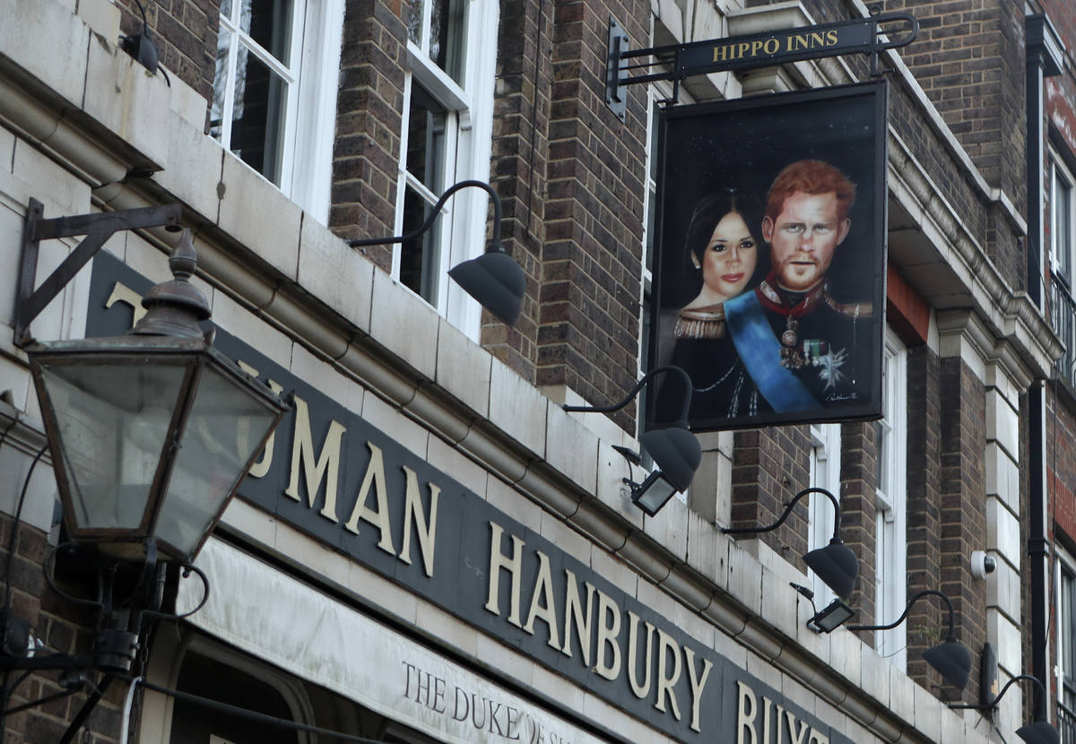 A sign showing Britain's Prince Harry and his wife Meghan, hangs outside the Duke of Sussex pub ...