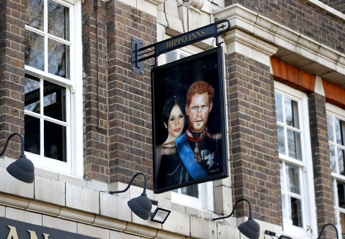 A sign depicting the image of Britain's Prince Harry and his wife Meghan, hangs outside the Duk ...