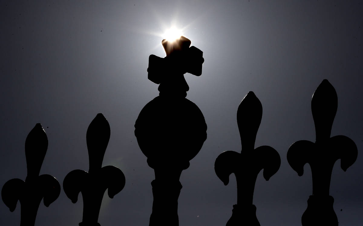 The sun rises above a railing at Buckingham Palace in London, Tuesday, March 9, 2021. Britain's ...