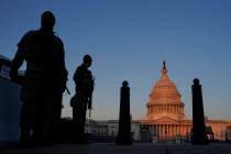 National Guard stand their posts around the Capitol at sunrise in Washington, Monday, March 8, ...