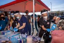 Touro University physician assistant student Andrew Trinh, right, gives another flu vaccine sho ...