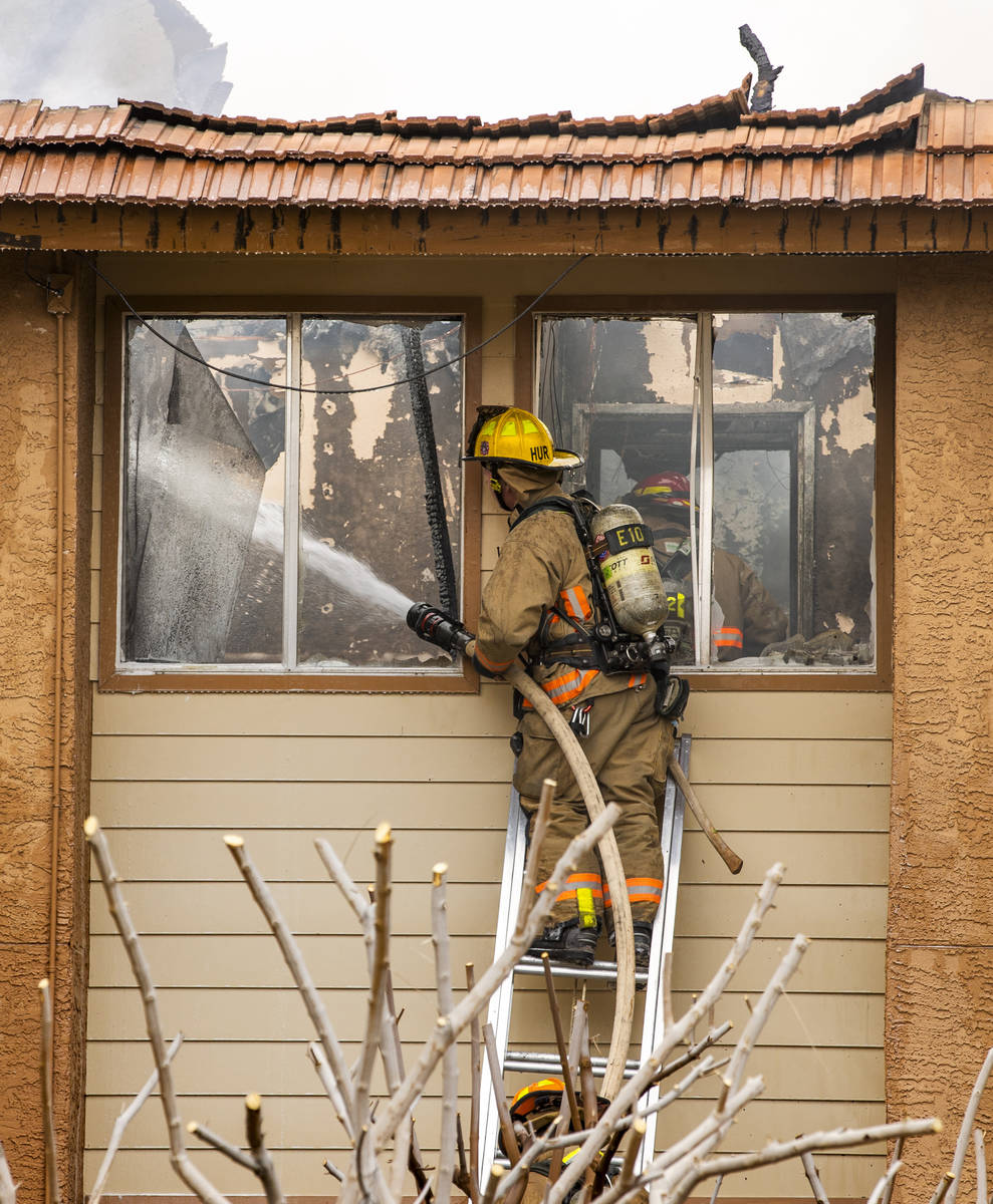 Clark County and Las Vegas Fire Department firefighters work the scene at building 42 during a ...