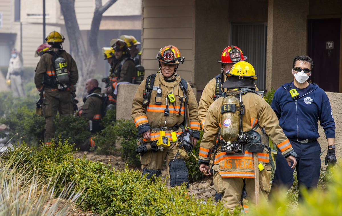 Firefighters walk about the scene as the Clark County and Las Vegas Fire Departments work a fir ...