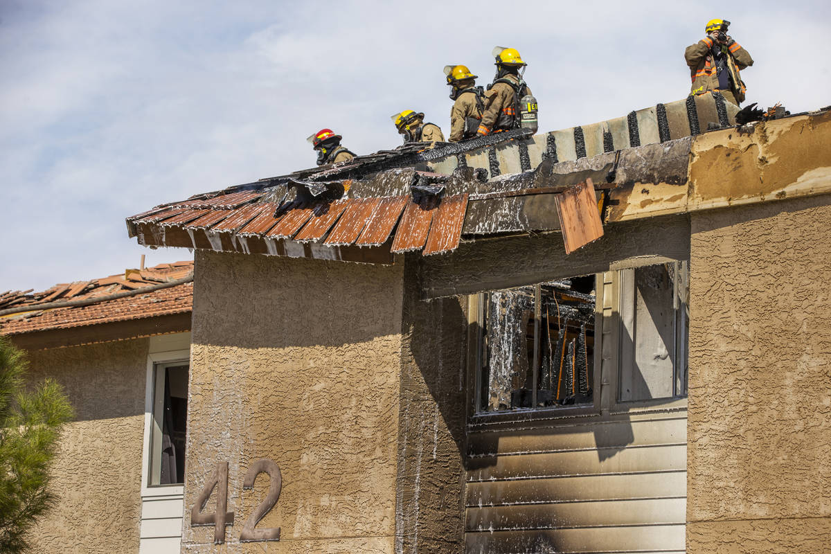 Clark County and Las Vegas Fire Department firefighters spray from atop of the roof as they wor ...