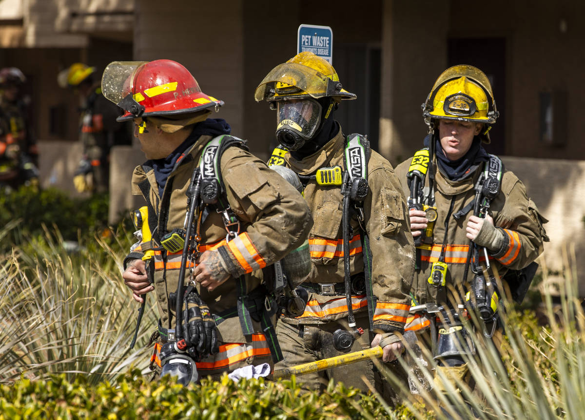 Firefighters walk about the scene as the Clark County and Las Vegas Fire Departments work a fir ...