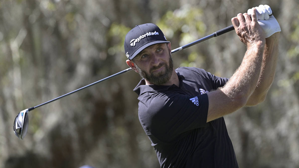 Dustin Johnson watches his tee shot on the ninth hole during the third round of the Workday Cha ...