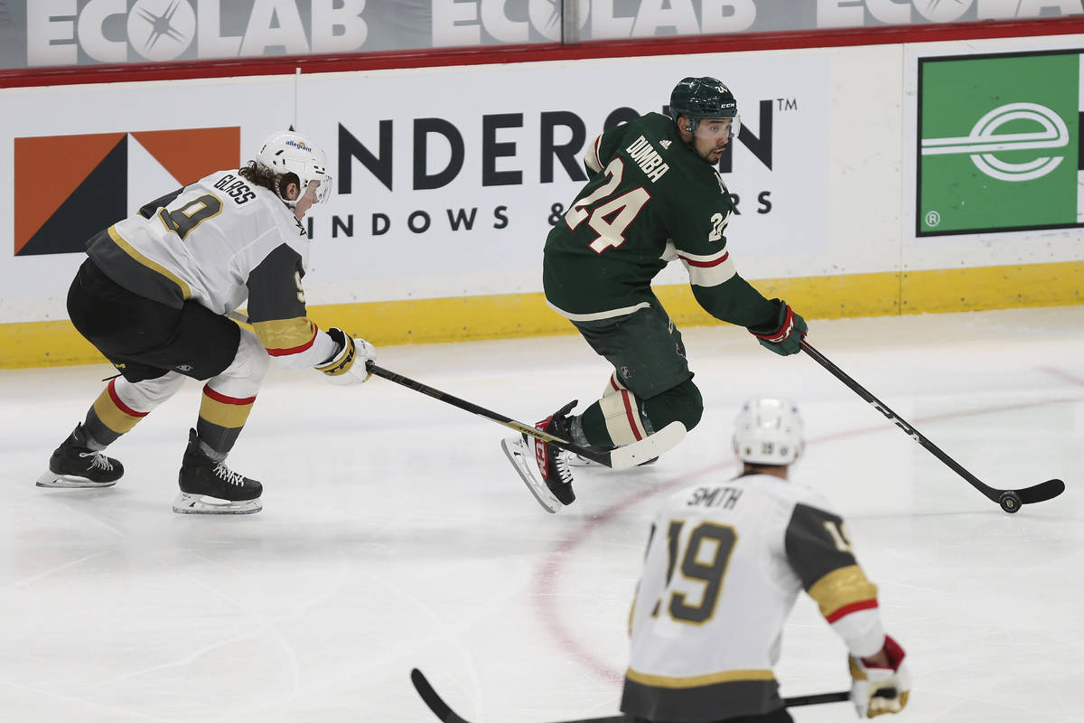 Minnesota Wild's Matt Dumba (24) controls the puck against Vegas Golden Knights' Cody Glass, le ...