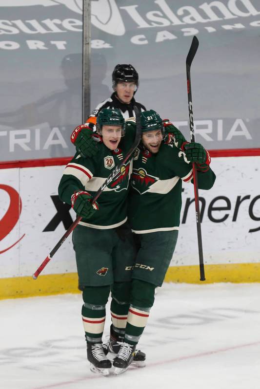 Minnesota Wild's Nico Sturm, left, celebrates with Carson Soucy (21) after Soucy scored a goal ...