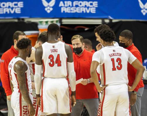 UNLV Rebels head coach T.J. Otzelberger, middle, draws up a play during a timeout in the first ...
