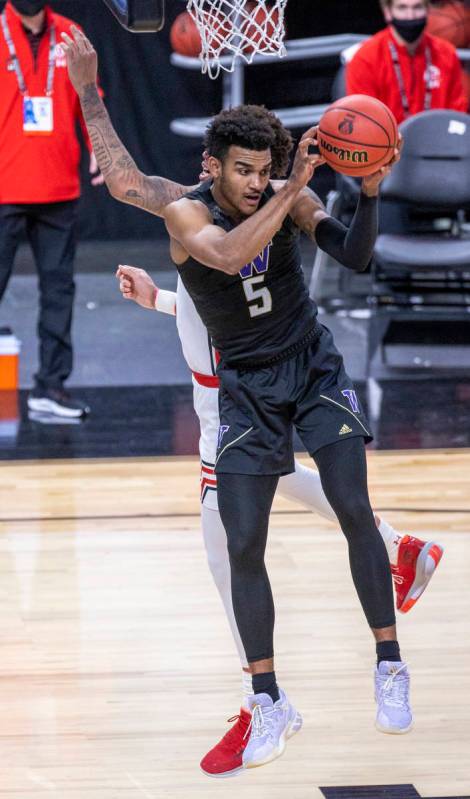 Washington Huskies guard Jamal Bey (5) grabs a rebound over the back of Utah Utes forward Timmy ...