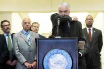 Governor Steve Sisolak demonstrates the best way to cough during a press conference at the Gran ...