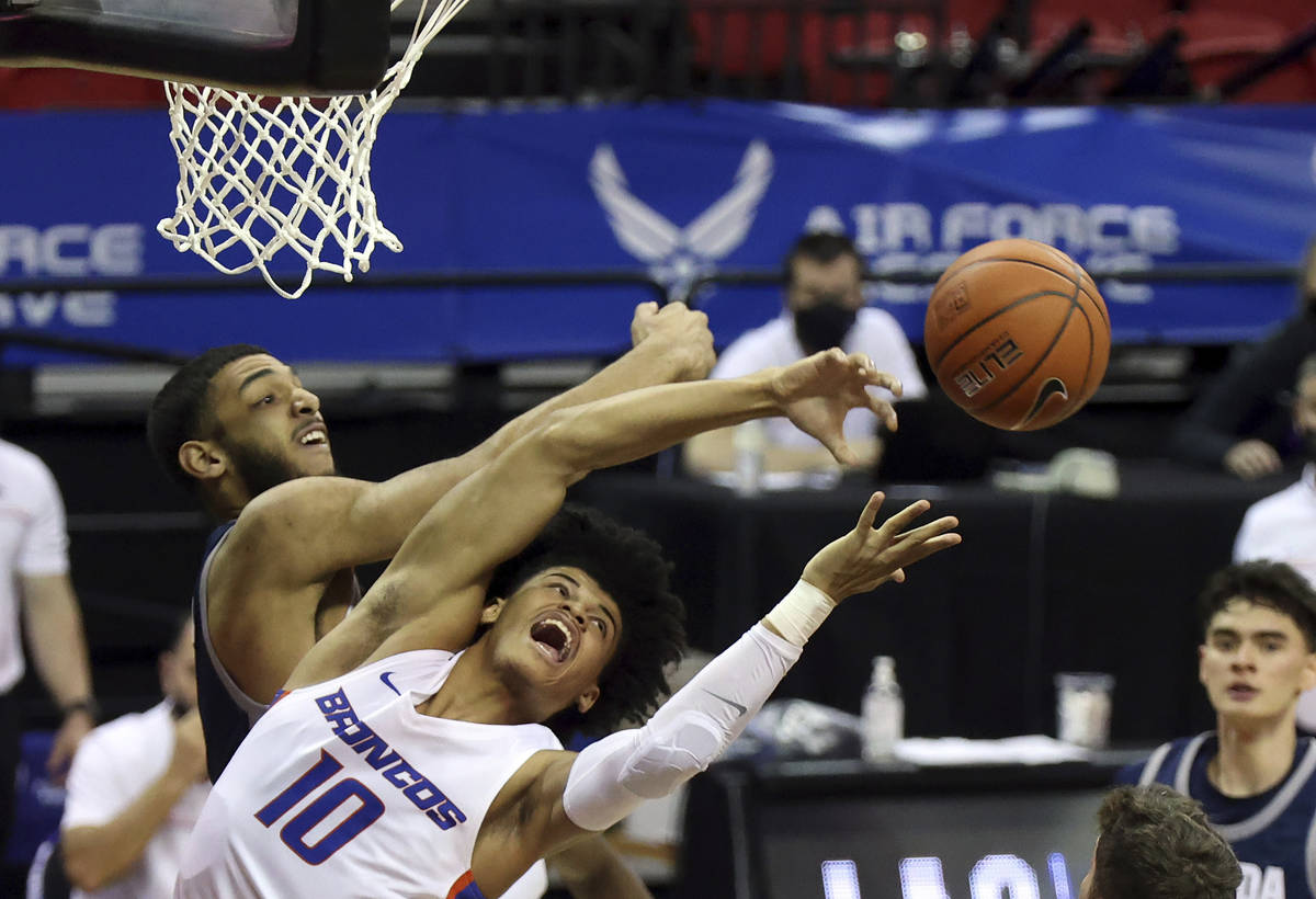 Nevada forward Robby Robinson, left, and Boise State guard RayJ Dennis (10) reach for a rebound ...