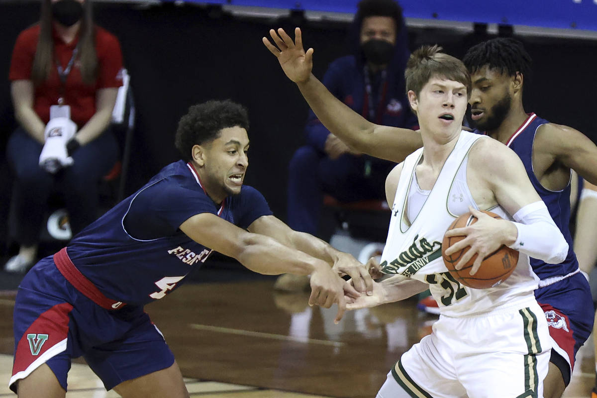 Fresno State guard Junior Ballard (4) reaches for the ball as Colorado State forward Adam Thist ...