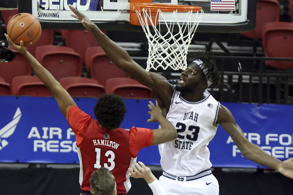 UNLV guard Bryce Hamilton (13) shoots as Utah State center Neemias Queta (23) defends during th ...