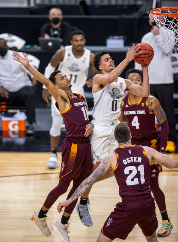 Oregon Ducks guard Chris Duarte (5) splits the defense of Arizona State Sun Devils guard Alonzo ...