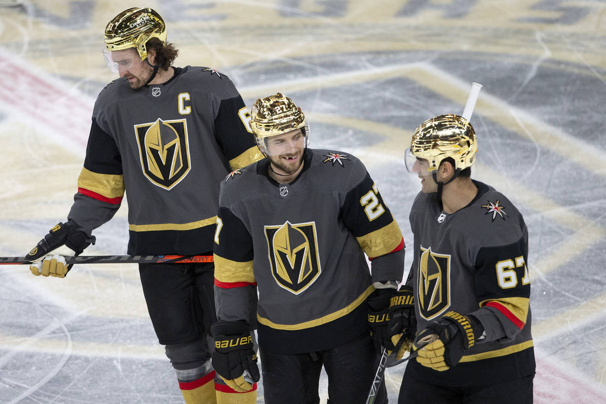 Golden Knights defenseman Shea Theodore (27) communicates with Golden Knights right wing Mark S ...