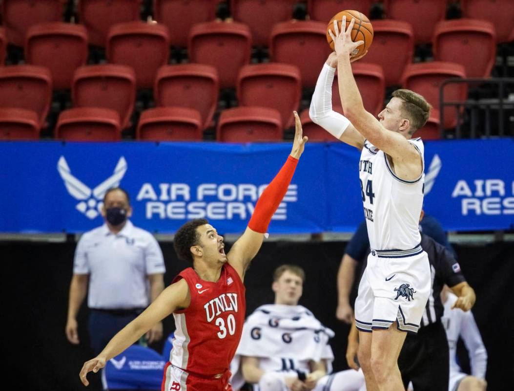 Utah State Aggies forward Justin Bean (34) shoots over UNLV Rebels forward Devin Tillis (30) in ...