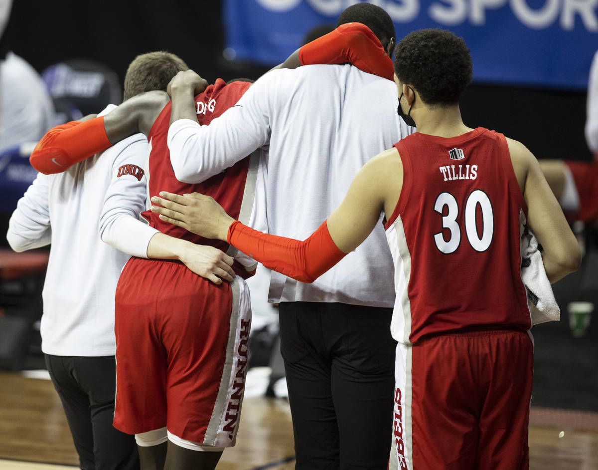 UNLV Rebels forward Cheikh Mbacke Diong (34) is helped off the court by UNLV Rebels forward Dev ...